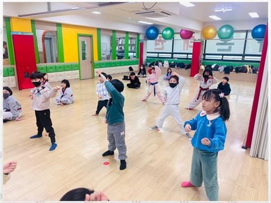 밝고 넓은 수련장에서 함께 운동하는 어린이들